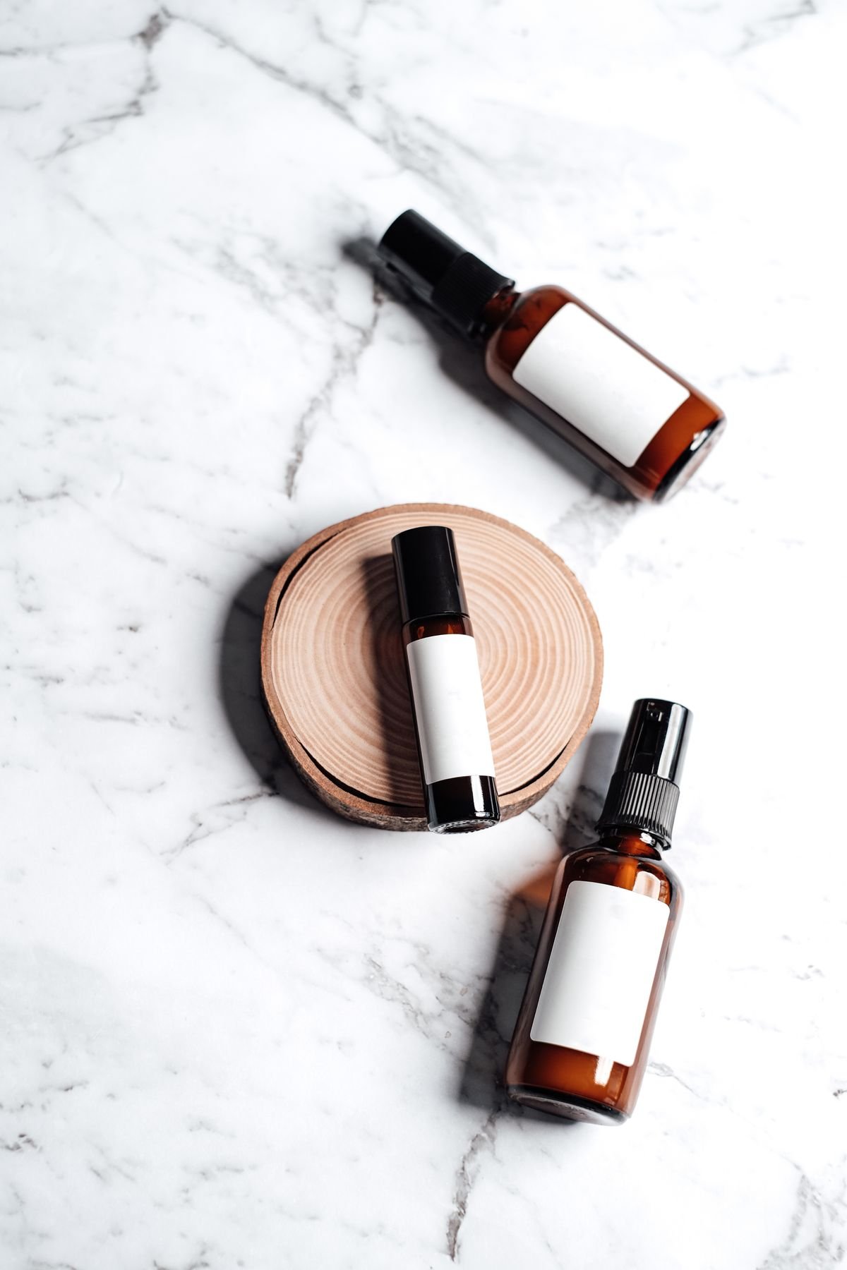 Brown glass skincare bottles on a marble surface