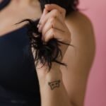 Close-up of a hand holding the dry, frayed ends of dark hair, showing hair breakage