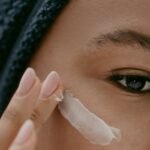 Woman smoothing a rich ceramide cream over her cheek